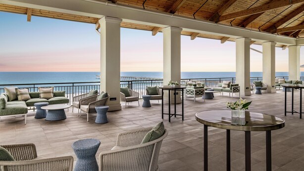 A covered outdoor area with seating and a view of the ocean. - Embassy Suites by Hilton Panama City Beach Resort (Panama City Beach)