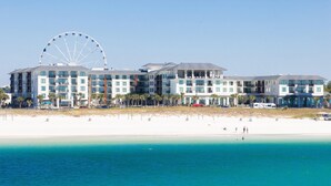 A beachfront hotel with multiple floors, a large Ferris wheel, and a sandy beach. - Embassy Suites by Hilton Panama City Beach Resort (Panama City Beach)