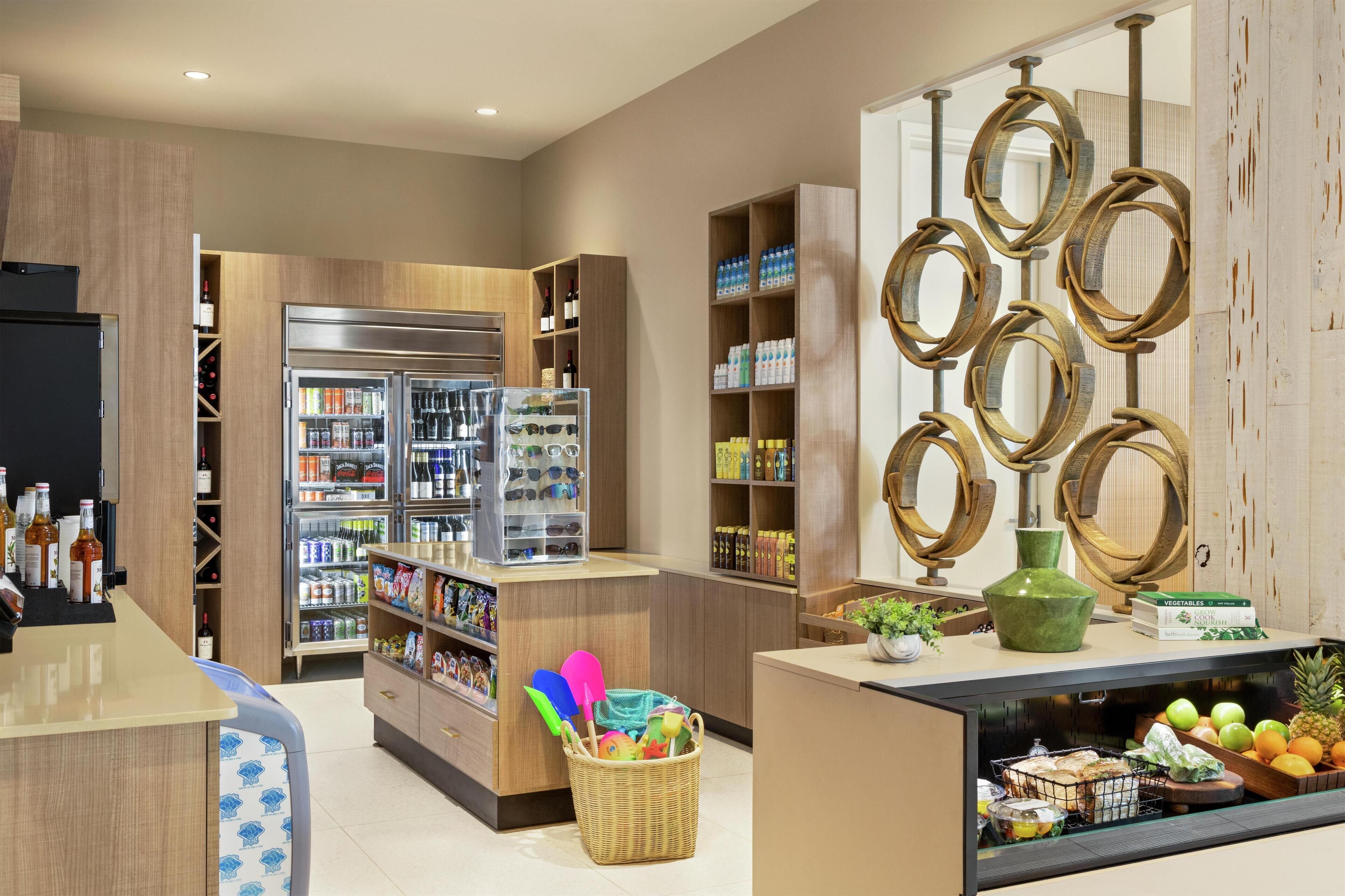 A modern kitchen with wooden cabinets, a refrigerator, and a fruit display.