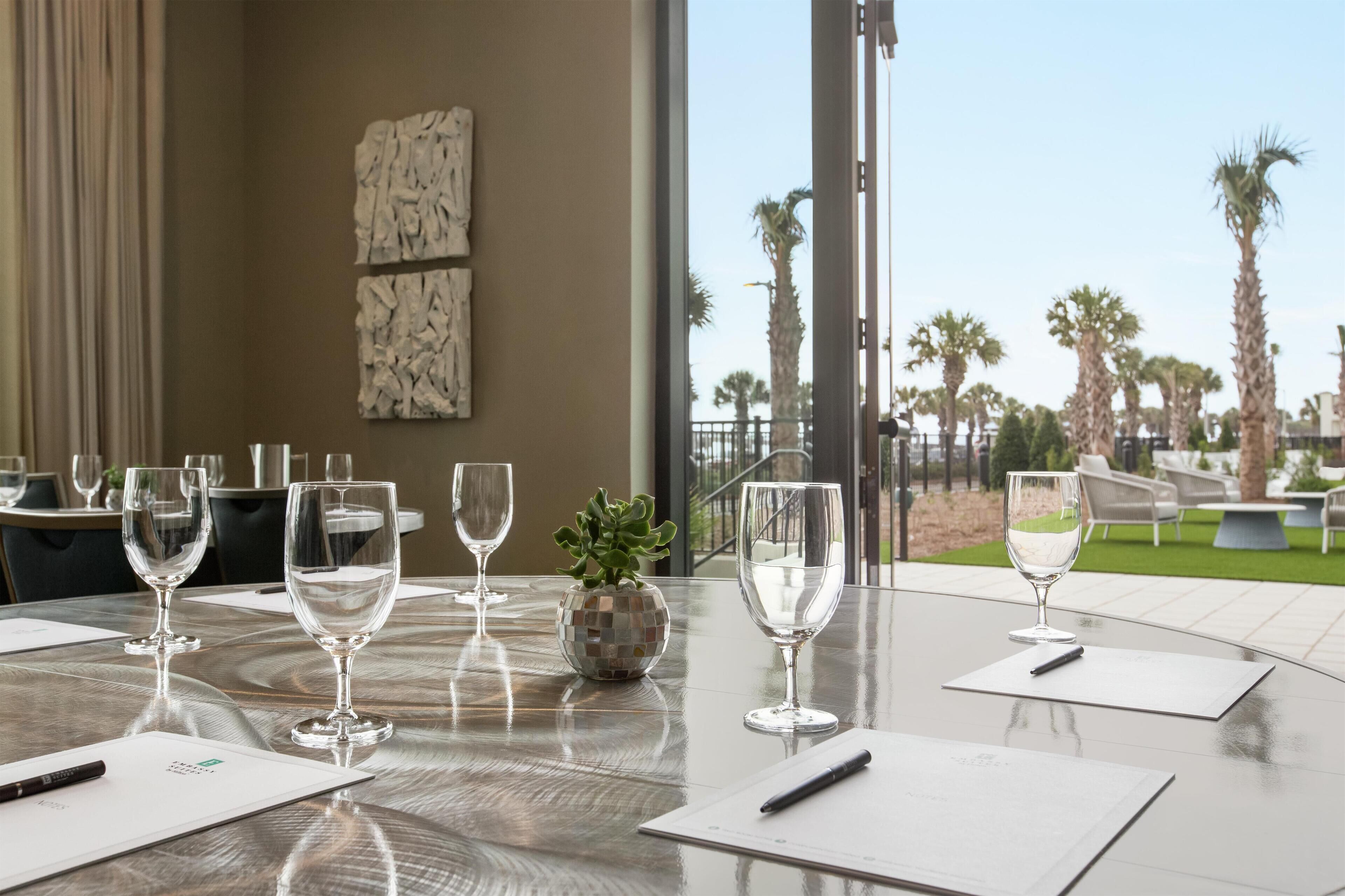 Une table de conférence avec des verres à vin vides, un stylo et un globe décoratif en guise de centre de table.