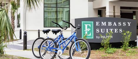 Señal de Embassy Suites by Hilton con una bicicleta azul estacionada al frente.
