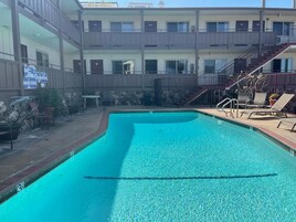 Una piscina al aire libre, sillones reclinables de piscina