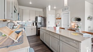 Una cocina moderna con armarios blancos, electrodomésticos de acero inoxidable y una isla de madera.