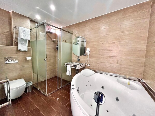 A modern bathroom with a glass-enclosed shower, a freestanding bathtub, a toilet, and a sink.