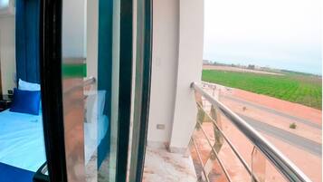 Un balcón con vistas a un campo verde y una carretera.