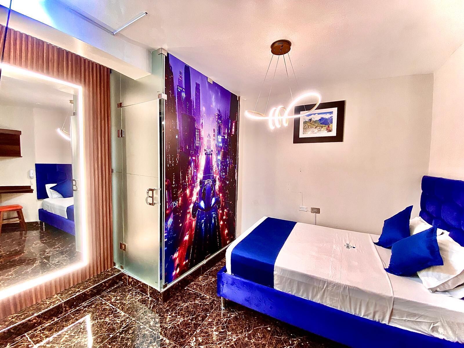 A modern hotel room with a large bed, a glass partition, and a cityscape mural on the wall.