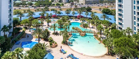 A resort with multiple swimming pools, palm trees, and a beach area with sun loungers.