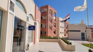 Un edificio con un letrero que dice 'VIP Reception', una bandera y un cielo despejado.
