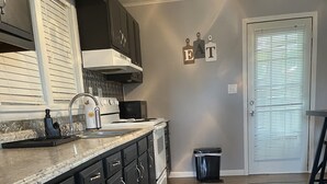 A modern kitchen with dark cabinets, a stainless steel sink, and a microwave. - Pigs Ina Blanket - Minutes from Rend Lake and I-64/I-57 (Ina)