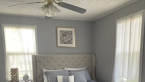 A bedroom with a bed, a nightstand, a ceiling fan, and a framed picture on the wall. - Pigs Ina Blanket - Minutes from Rend Lake and I-64/I-57 (Ina)