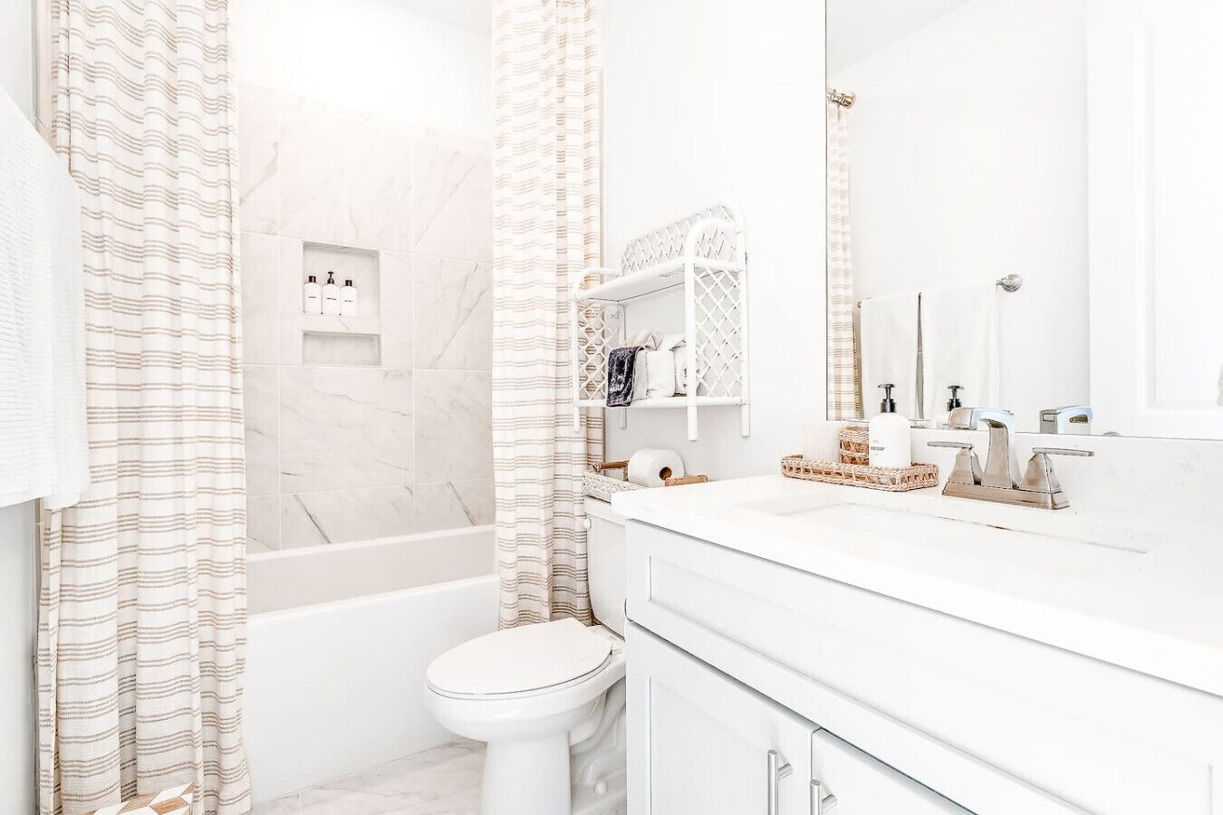 A modern bathroom with a bathtub, toilet, and vanity with a mirror.