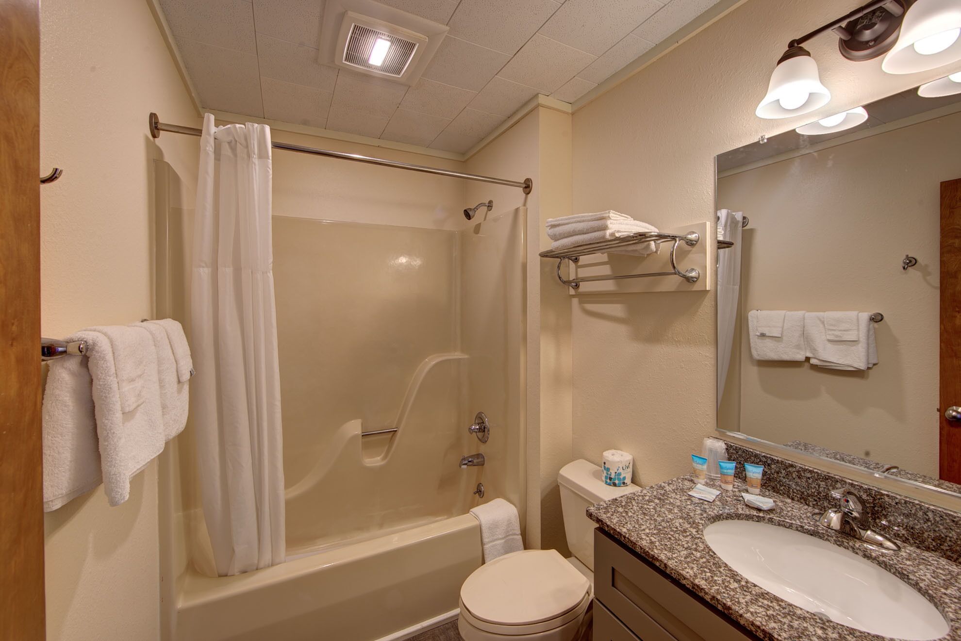 Une salle de bain équipée d’une baignoire, de toilettes, d’un lavabo et d’un miroir.
