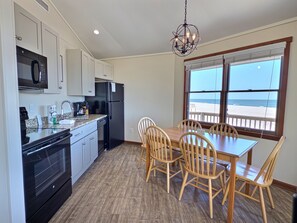 Una cucina con zona pranzo, vista sulla spiaggia e un lampadario.