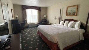 A hotel room with a large bed, a desk with a computer, a chair, a window with curtains, and a painting on the wall. - Surestay Hotel By Best Western Eureka (Eureka)