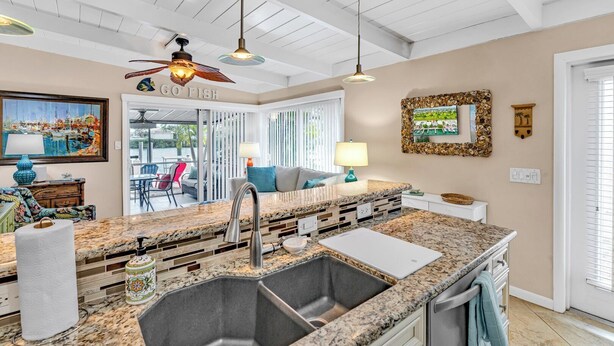 A kitchen with granite countertops, a sink, and a ceiling fan. - P14 - Charming 2 Bedroom, 2 bath waterfront duplex with Cabana Club. (Key Colony Beach)