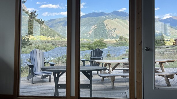 A room with a view of a river and mountains through large windows. - Pagenkopf House on the Madison River (Cameron)