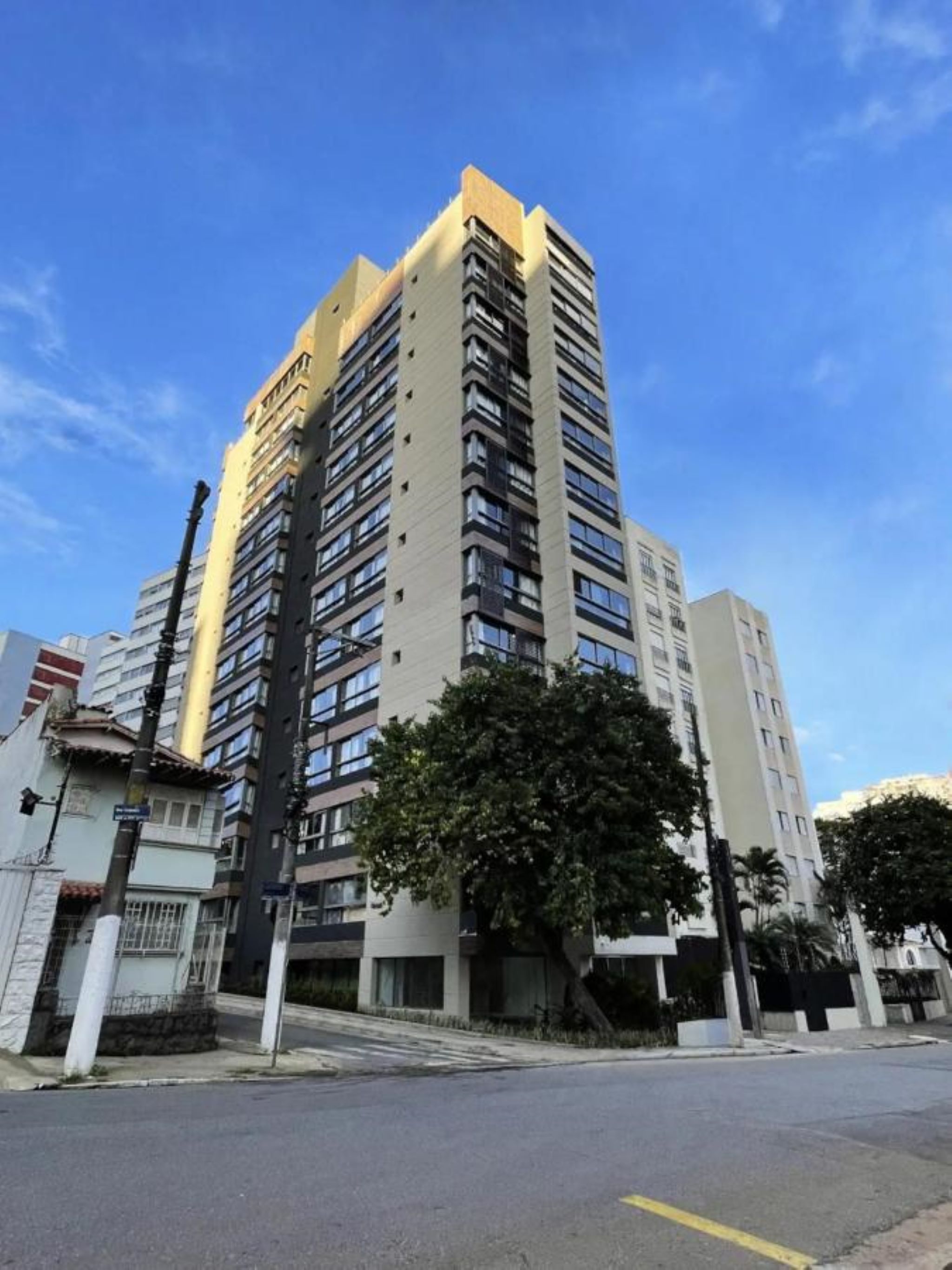 A multi-story residential building with a modern architectural design, featuring balconies and a flat roof.