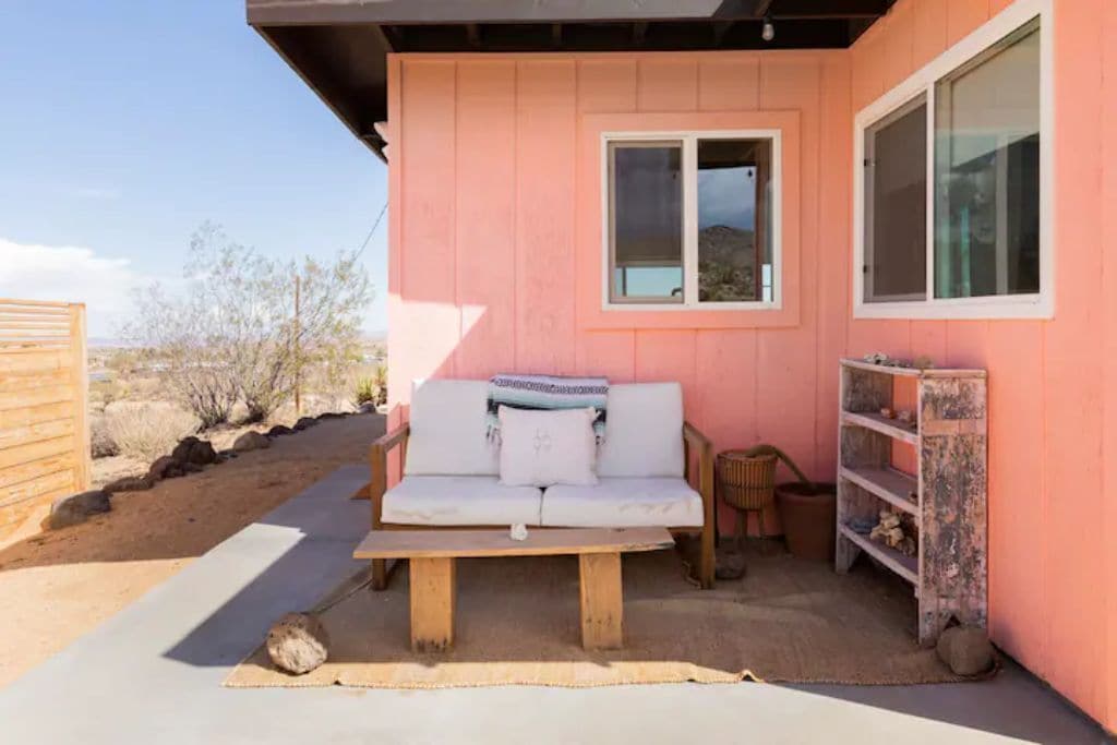A pink building with a white sofa and a small table.