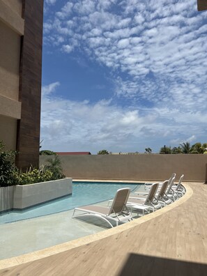 Une piscine avec des chaises longues et une vue sur le ciel.