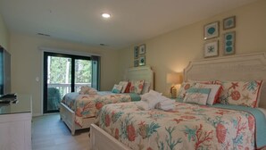 A bedroom with two beds, a large window, and a sliding door leading to a balcony. - Spacious Condo in the Heart of Hilton Head (Hilton Head Island)