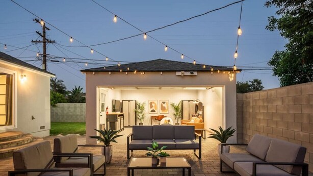 An outdoor patio area with a sofa, chairs, and a coffee table. - Luxury Hangout | Private Spa + Game Room + Arcade (Long Beach)