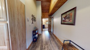 A hallway with wooden floors, a framed picture on the wall, and a small table with a chair. - Escape to Pine Creek and PA Grand Canyon stay at Willow Cabin (Gaines)