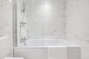 Bathtub, hair dryer, towels, shampoo