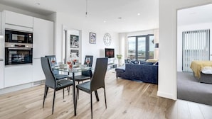 Un appartement moderne comprenant un coin repas, une cuisine et un espace de vie.