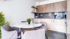 Uma cozinha moderna com armários de madeira, uma mesa de mármore e um laptop sobre a mesa.