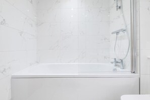 Banheira, secador de cabelo, toalhas de banho, shampoo