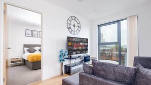 Un apartamento moderno con sala de estar, un dormitorio y un ventanal grande.