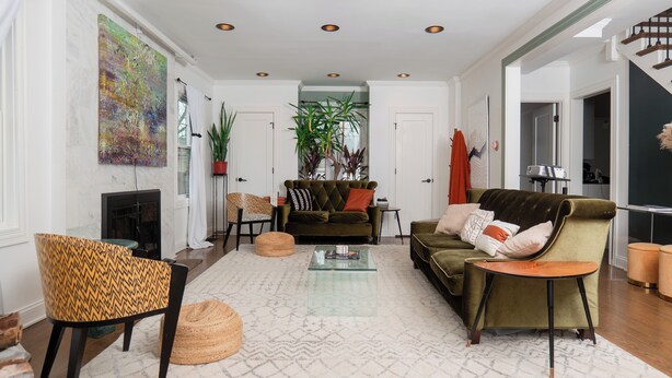 Amplia sala de estar con chimenea, un sofá, una mesa de centro y un cuadro grande en la pared.