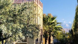 A building with a castle-like facade, surrounded by greenery and a clear sky. - Private Villa With Swimming Pool in Lalla Takerkousst-marrakech (Lalla Takarkoust)