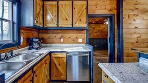 A kitchen with wooden cabinets, stainless steel appliances, and granite countertops.