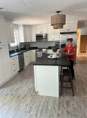 Enjoy cooking in this well-equipped kitchen with a central island, microwave, oven, and refrigerator.