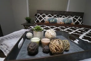 Cozy retreat with a neatly arranged bed, decorative pillows, and a potted plant.