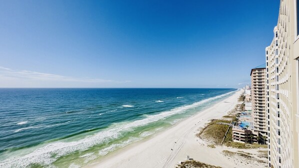 A beachfront hotel with a view of the ocean and a pier.
