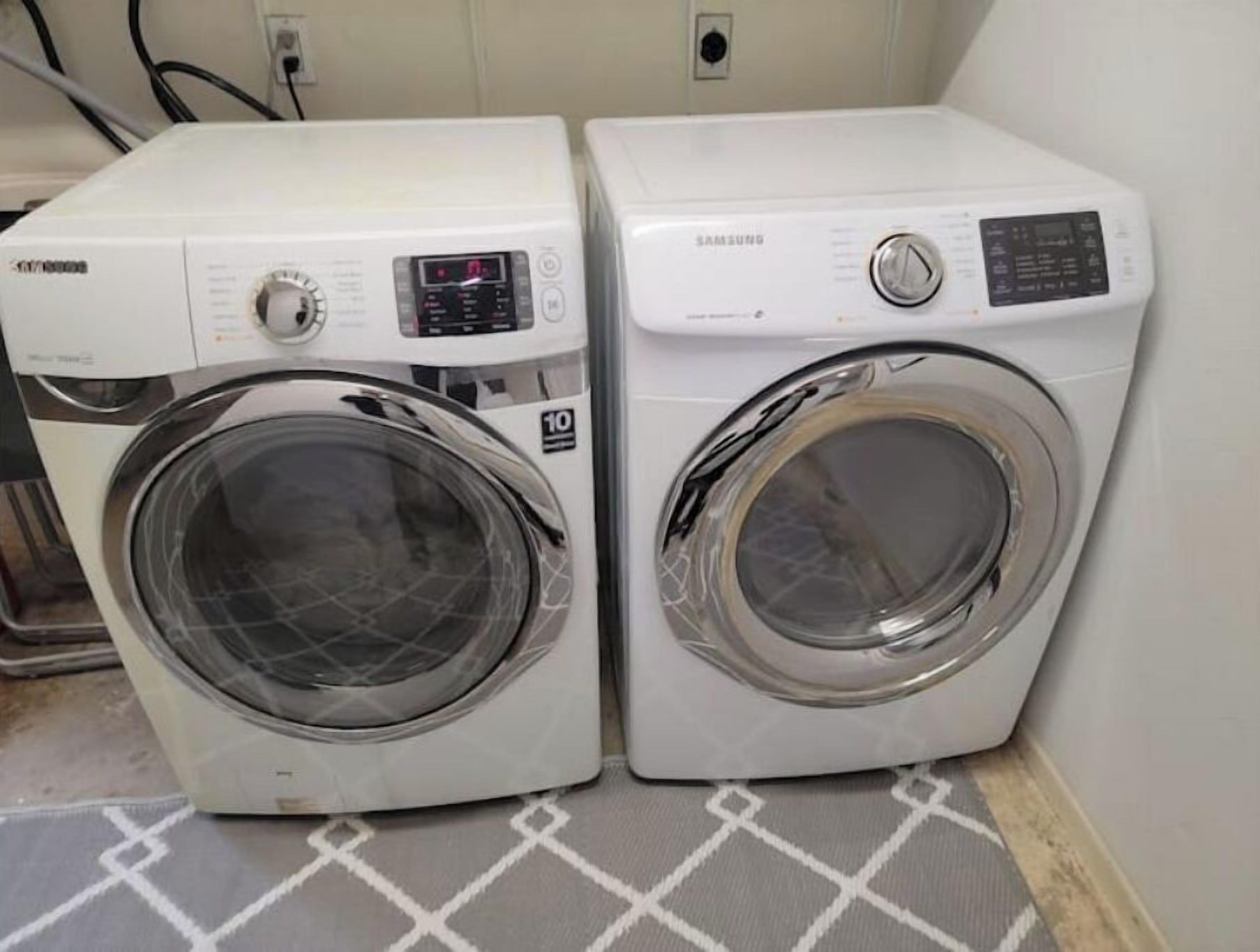 Two front-loading washing machines in a laundry room with a patterned floor.