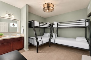 A bunk bed room with a sink and mirror, a ceiling light fixture, and a small plant on the counter. - Spacious 3BR/2.5BA Townhouse • Near Hwy 76 Strip • Balcony, WiFi (Branson)