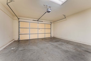A garage with a concrete floor, a metal garage door, and a ceiling-mounted light fixture. - Spacious 3BR/2.5BA Townhouse • Near Hwy 76 Strip • Balcony, WiFi (Branson)