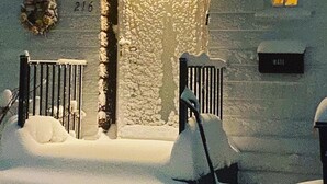A snow-covered entrance with a stone wall, a mailbox, and a wreath. - Your adventure home base for skiing, snowboarding, hiking and biking! (Ironwood)