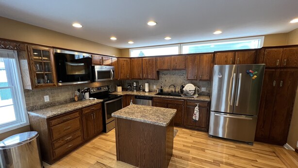 A modern kitchen with wooden cabinets, stainless steel appliances, and a granite countertop. - Your adventure home base for skiing, snowboarding, hiking and biking! (Ironwood)