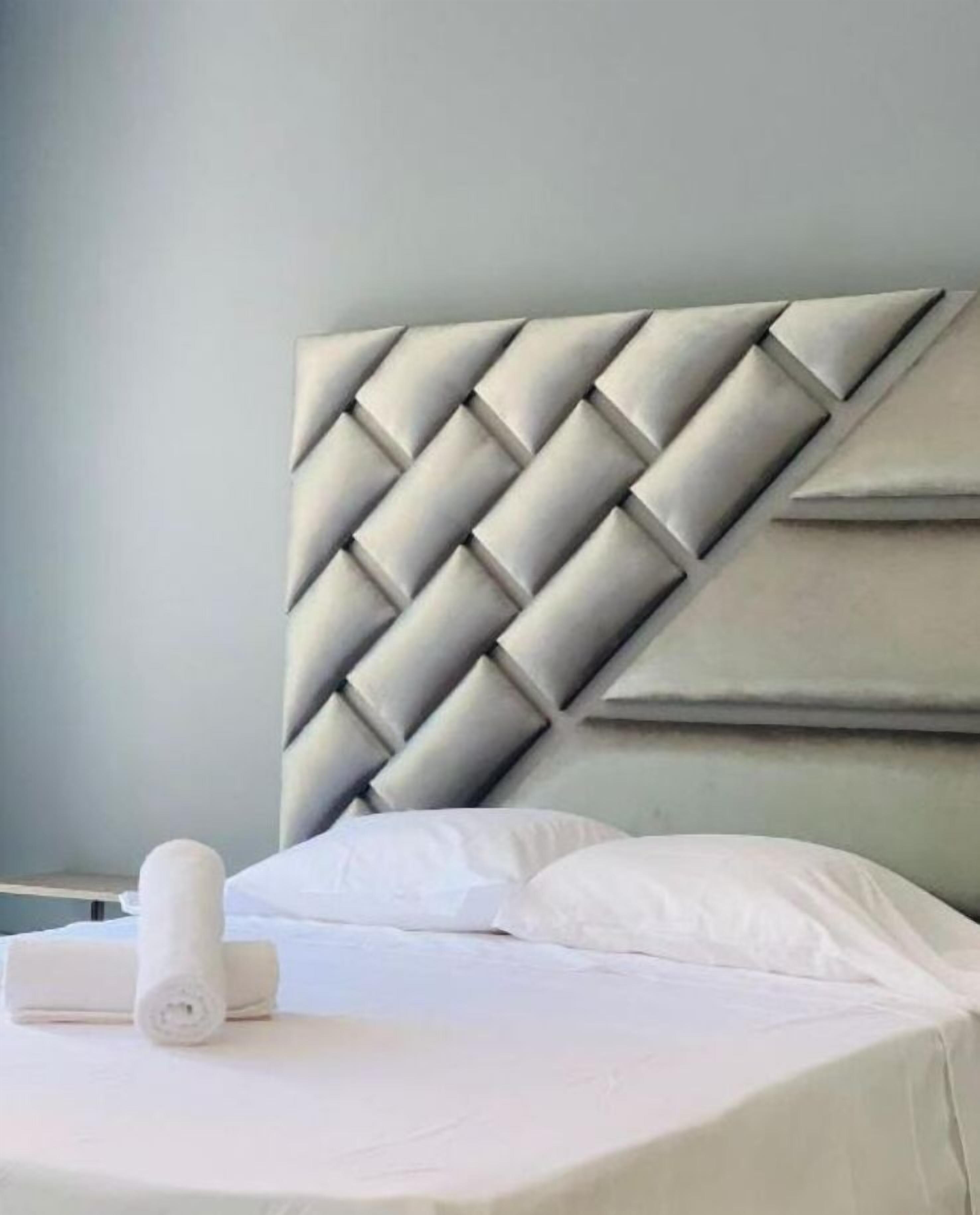 A bed with a headboard featuring a geometric pattern.