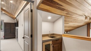 Eine moderne Küche mit Holzbalkendecke, einer eingebauten Spüle und einer kleinen Arbeitsfläche.
