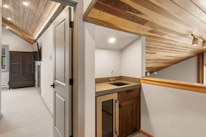 A modern kitchen with wooden ceiling beams, a built-in sink, and a small countertop.