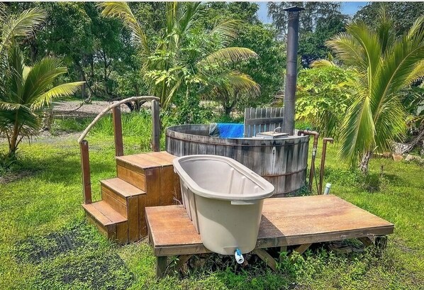 Relax in a serene hot tub surrounded by lush greenery and tropical plants.