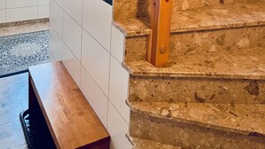 Una escalera con balaustres de madera y detalles de mármol.