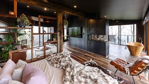 Un soggiorno moderno con una soffice coperta in pelliccia, arredi in legno e vista sull'esterno.