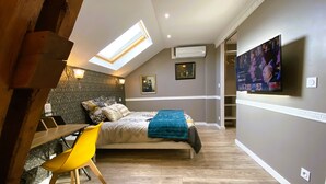 A bedroom with a bed, a desk, a chair, a TV, and a skylight. - Cosy duplex - between lakes and mountains - NO PARTIES ALLOWED (Fillinges)