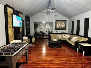 Relax in this spacious living room with a foosball table, comfortable sofa, and dining area.